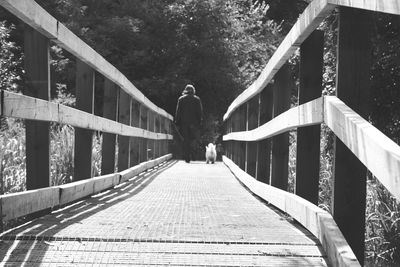 Rear view of woman walking on footbridge