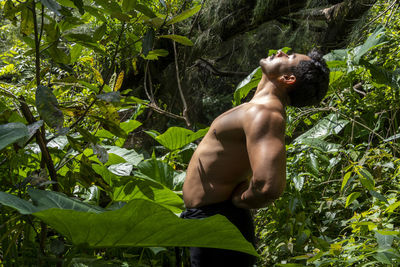 Man seen up close, without shirt doing stretches on yoga mat, exercise, latin america