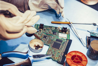 High angle view of hands holding camera on table