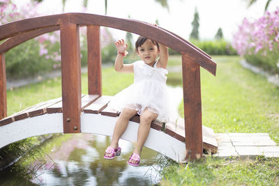 Portrait of young woman standing by railing