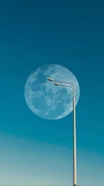 Low angle view of street light against blue sky