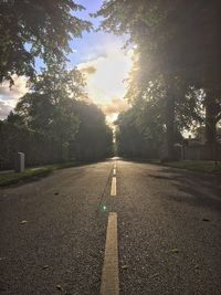 Road by trees against sky