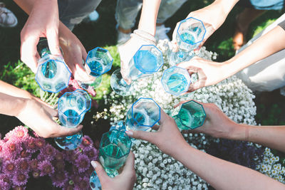 High angle view of people toasting drinks while standing outdoors