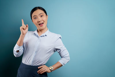 Portrait of a smiling young woman against blue background