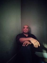 Portrait of young man leaning against wall