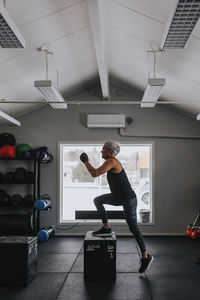 Side view of mature woman training in gym