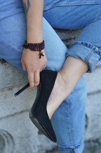 Low section of woman wearing shoe