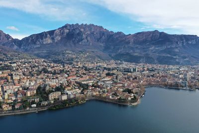 Aerial view of townscape by sea against sky