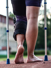 Hurt runner walk by forearm crutches on running track after finished competition. track of stadium