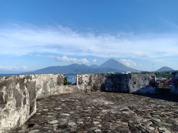 Scenic view of buildings and mountains against blue sky