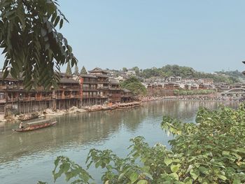 Scenic view of river and buildings against clear sky
