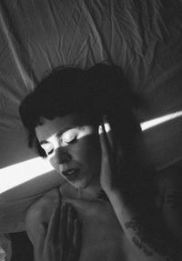 Portrait of shirtless boy on bed at home