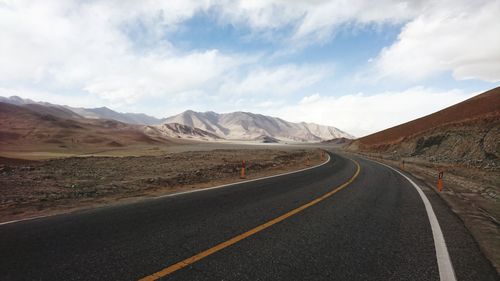 Empty road in desert against sky