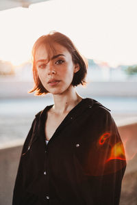 Portrait of young woman standing against sea