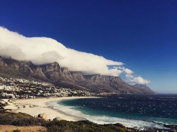 Scenic view of sea and mountains against blue sky