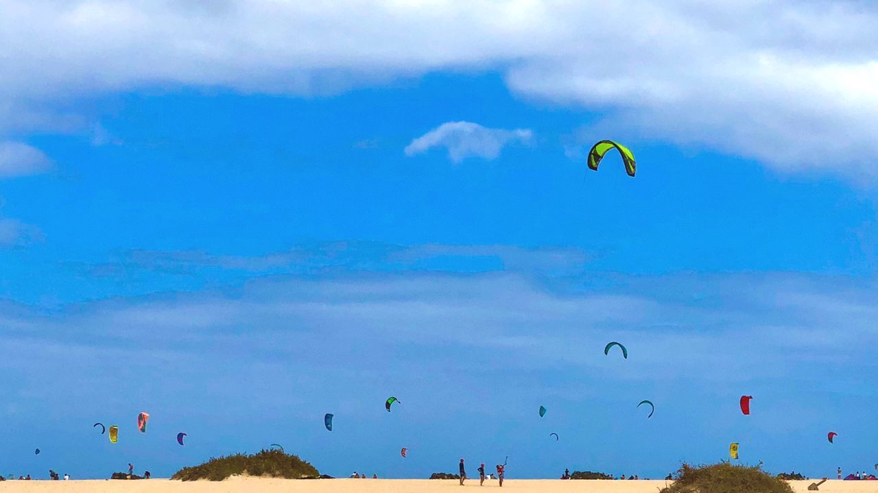 LOW ANGLE VIEW OF PEOPLE FLYING KITE AGAINST SKY