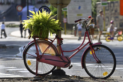 Bicycle parked on sidewalk by road in city