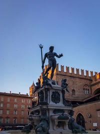 Low angle view of angel statue against clear blue sky