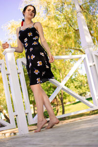 Young woman standing by railing