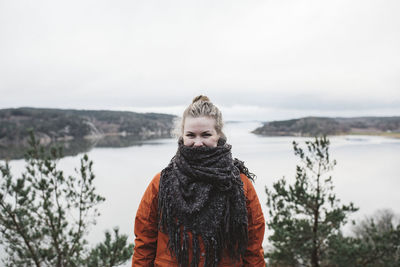 Woman standing in snow against sky during winter