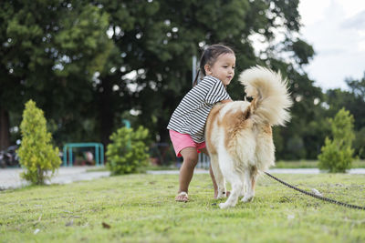 Side view of woman with dog on field