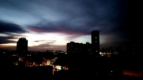 Silhouette buildings against sky at night