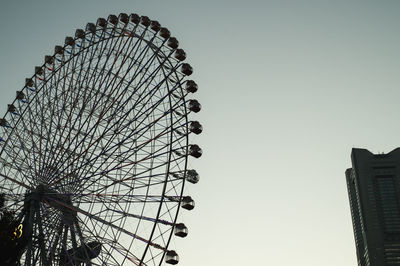 Low angle view of ferris wheel against clear sky