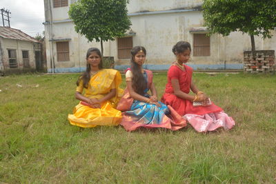 Rear view of women sitting on grass