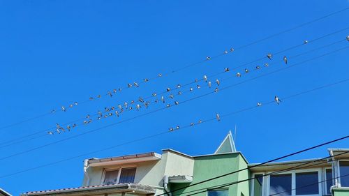 Low angle view of buildings against clear blue sky