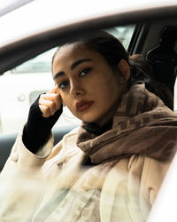 Portrait of young woman in car