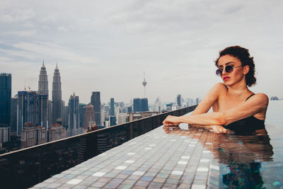 Portrait of woman swimming in infinity pool