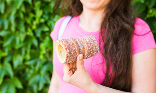 Midsection of woman holding pink food