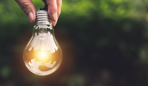 Close-up of hand holding light bulb