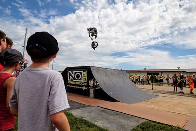 Rear view of people on skateboard against sky