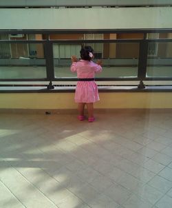 Rear view of woman standing on tiled floor