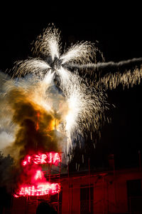 Low angle view of firework display at night