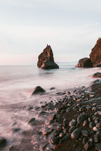 Scenic view of rocks in sea against sky