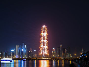 Illuminated buildings against sky at night