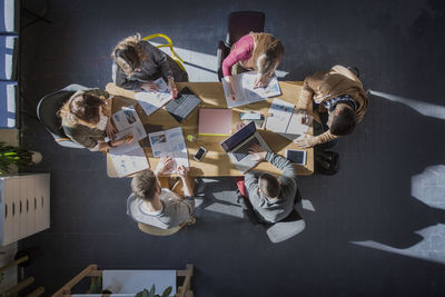 Overhead view of students studying at table in classroom