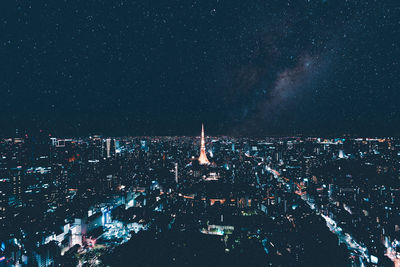 Illuminated tokyo tower amidst buildings against sky at night