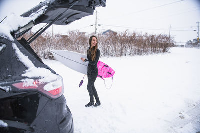 Woman going surfing during winter snow