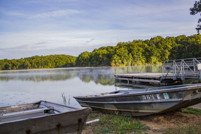 Boat moored in lake against sky