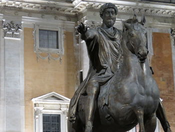 Low angle view of statue against building in city