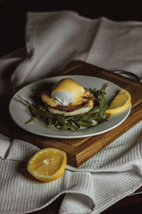 Eggs benedict and poached hollandaise sauce with arugula and lemon. delicious food for breakfast.