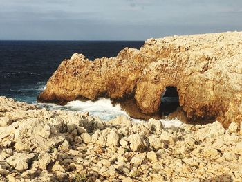 Scenic view of rocks on beach against sky