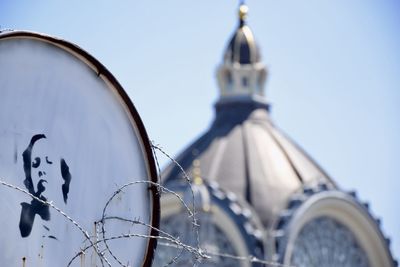 Low angle view of cross on building against sky