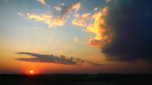 Low angle view of dramatic sky over silhouette landscape