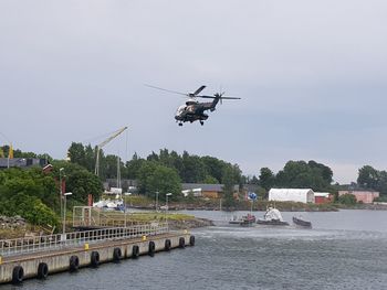 View of helicopter over river against sky