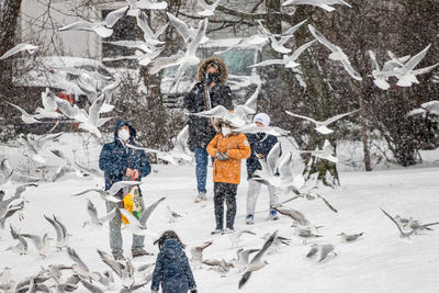 People standing on snow covered landscape during winter