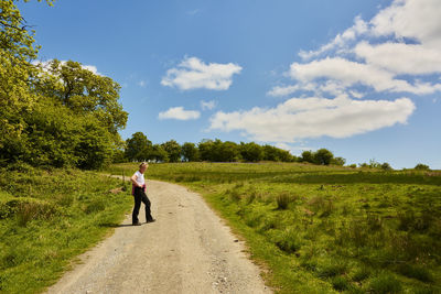 Full length of woman walking on grassy field